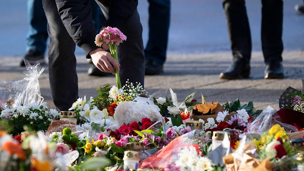 Ein Passant legt Blumen vor dem Eingang der Johanniskirche nieder. 