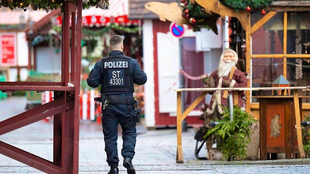A police officer walks through the closed Christmas market. Photo: Sebastian Kahnert/dpa