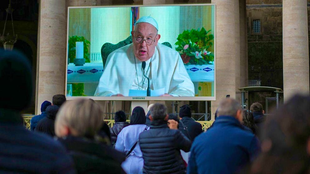People look at a giant screen in St. Peter's Square at the Vatican. Photo: Andrew Medichini/AP/dpa