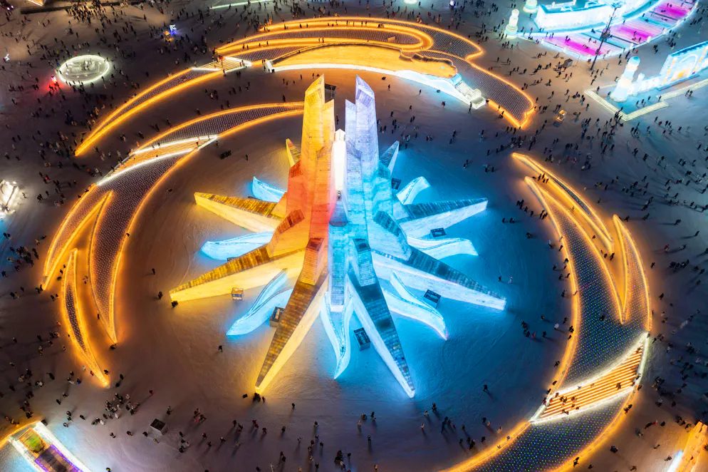 Harbin Internationales Eis- und Schneeskulpturen-Festival: Nachts werden die riesigen Gebäude und Skulpturen bunt beleuchtet.