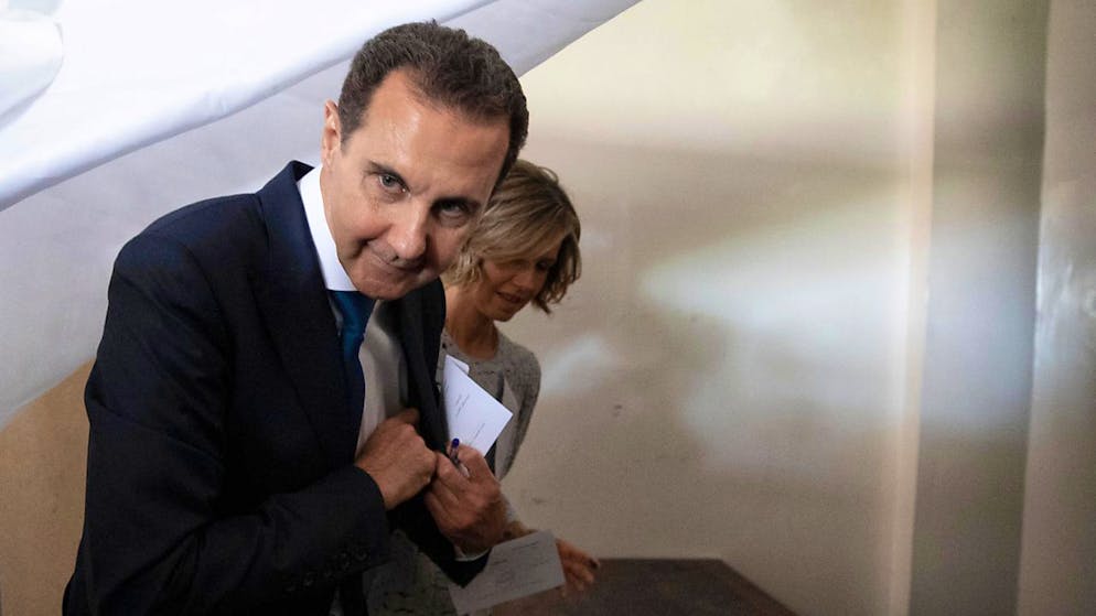 ARCHIV - Der damalige syrische Präsident Baschar al Assad und seine Frau Asma bereiten sich auf die Stimmabgabe in einem Wahllokal in der Stadt Douma vor. Foto: Hassan Ammar/AP/dpa