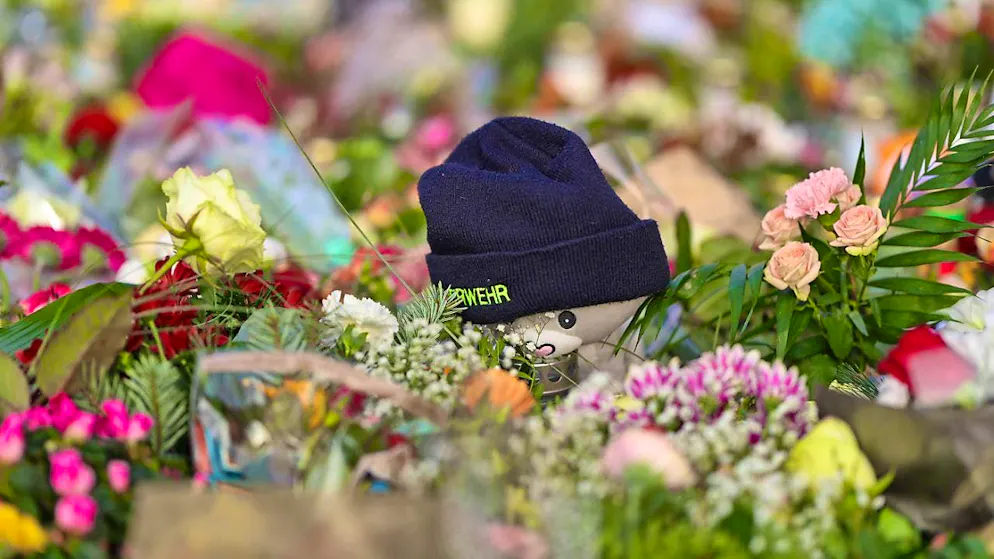 After the attack on Magdeburg's Christmas market, candles, flowers, cuddly toys and a fire department cap lie in front of St. John's Church, the central memorial site. Photo: Matthias Bein/dpa