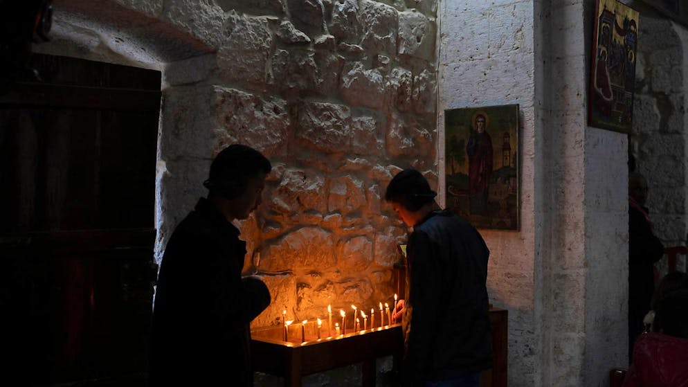 Christen zünden Kerzen an, bevor sie an der Christmette im griechisch-orthodoxen Kloster Saint Takla in Maaloula teilnehmen, etwa 60 km nördlich von Damaskus. Foto: Leo Correa/AP/dpa