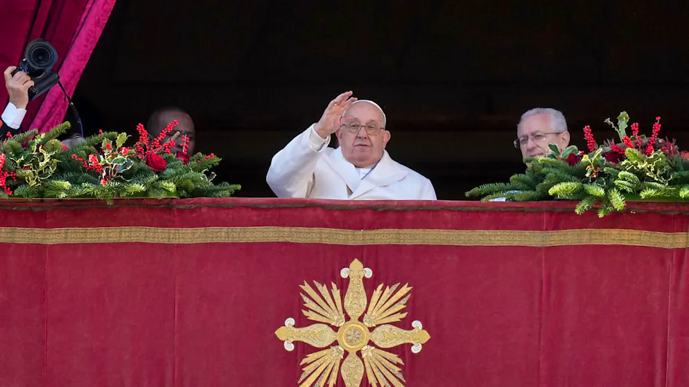 Papst Franziskus (M) winkt, bevor er vom Hauptbalkon des Petersdoms im Vatikan den Weihnachtssegen erteilt. Foto: Andrew Medichini/AP/dpa