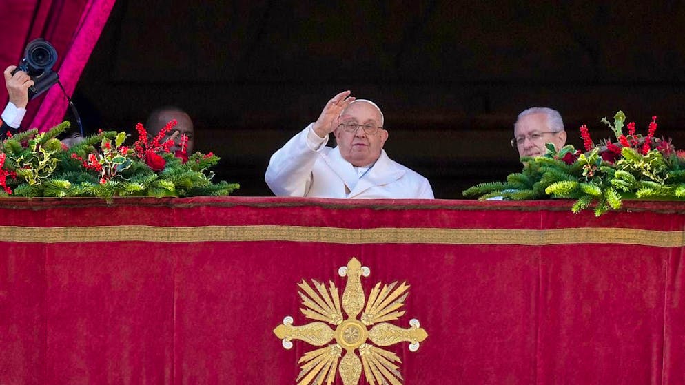 Pope Francis (M) waves before giving the Christmas blessing from the main balcony of St. Peter's Basilica in the Vatican. Photo: Andrew Medichini/AP/dpa