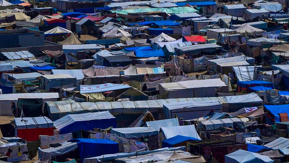 ARCHIVE - Palestinians displaced by the Israeli air and ground offensive in the Gaza Strip walk through a makeshift tent camp. Photo: Abdel Kareem Hana/AP/dpa