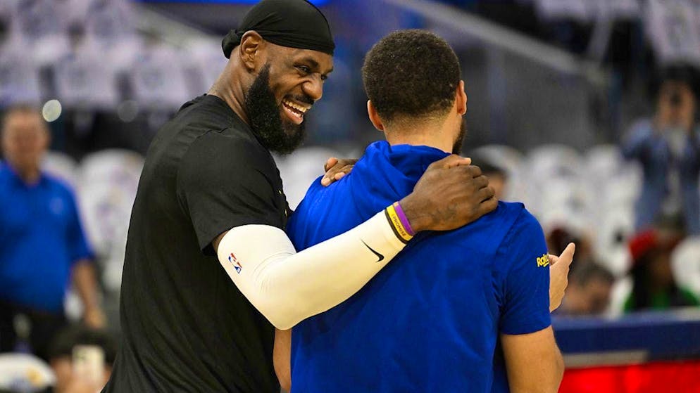 LeBron James (left) jokes with Stephen Curry before the game