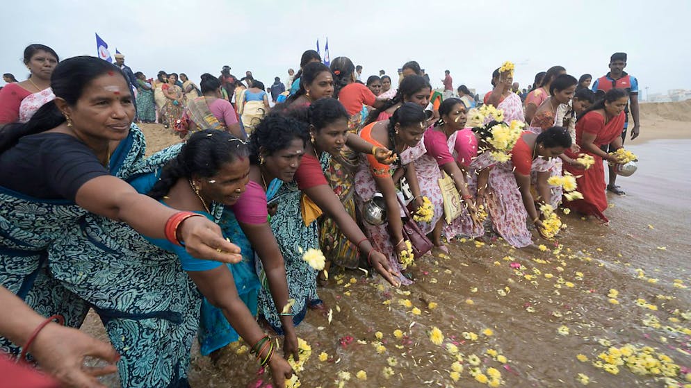 Menschen gedenken der Opfer des Tsunami von 2004 am 20. Jahrestag am Marina Beach. Ein Seebeben der Stärke 9,0 vor der indonesischen Insel Sumatra löste gewaltige Flutwellen - Tsunamis - aus, die die Küsten des Indischen Ozeans verwüsteten. Etwa 230.000 Menschen kamen ums Leben, darunter auch 552 Deutsche. Foto: Mahesh Kumar A./AP/dpa