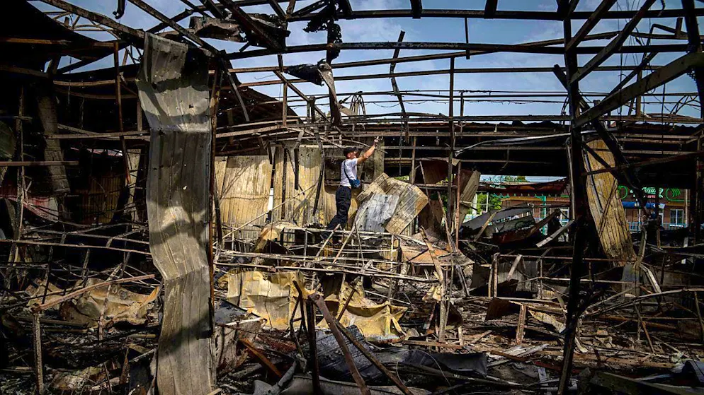 ARCHIVE - A man collects copper wires at a market that was destroyed by Russian shelling. Photo: Evgeniy Maloletka/AP/dpa