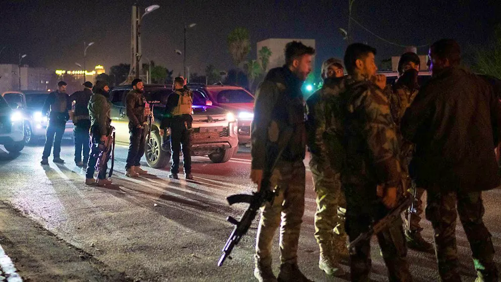 Syrian fighters gather on a street in Damascus at night. Photo: Leo Correa/AP/dpa