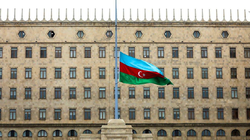 Die aserbaidschanische Nationalflagge weht vor einem Regierungsgebäude auf Halbmast zum Gedenken an die Opfer der Embraer 190 der Azerbaijan Airlines, die in der Nähe des kasachischen Flughafens Aktau abgestürzt ist. Foto: Aziz Karimov/AP/dpa