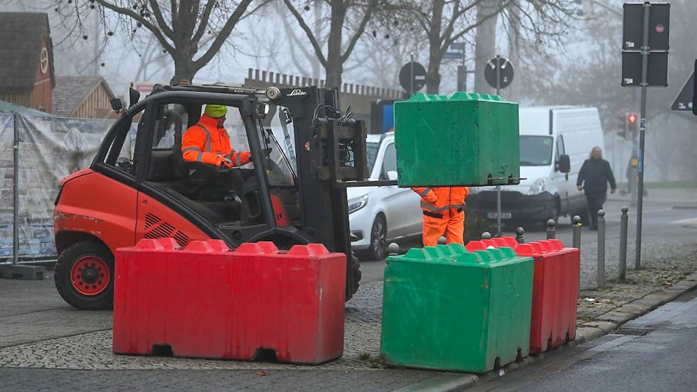 Die Betonblöcke, welche zur Sicherung des Weihnachtsmarktes dienen sollten, werden abgebaut und verladen. Foto: Heiko Rebsch/dpa