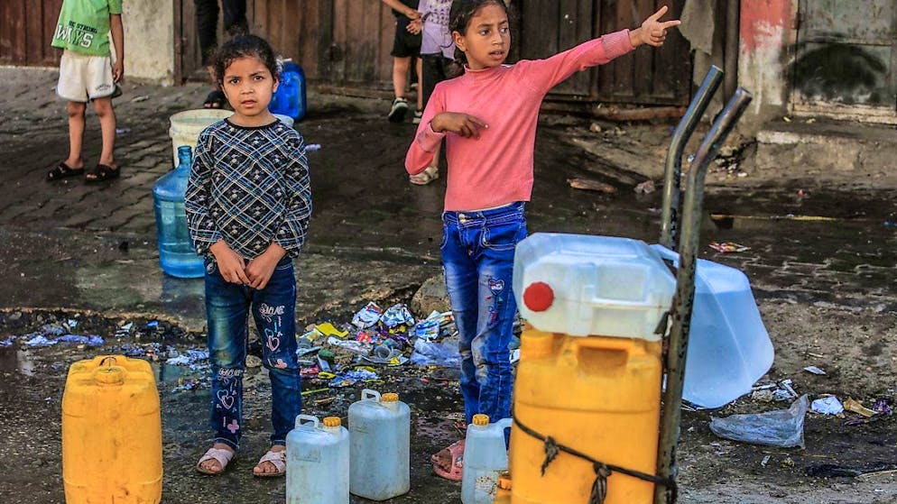 ARCHIVE - Palestinian children queue up with water containers to fill them with drinking water. Due to the destruction of wells during the ongoing attacks on the Gaza Strip, Palestinians have problems getting clean water. Photo: Abed Rahim Khatib/dpa