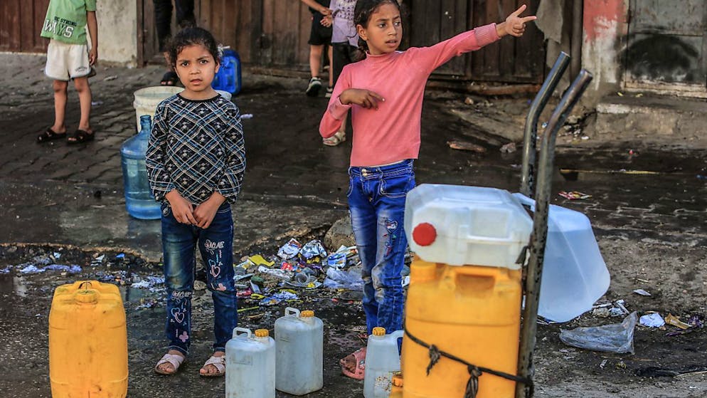 ARCHIV - Palästinensische Kinder stehen mit Wasserbehältern Schlange, um sie mit Trinkwasser zu füllen. Aufgrund der Zerstörung von Brunnen während der anhaltenden Angriffe auf den Gazastreifen haben die Palästinenser Probleme, sauberes Wasser zu bekommen. Foto: Abed Rahim Khatib/dpa