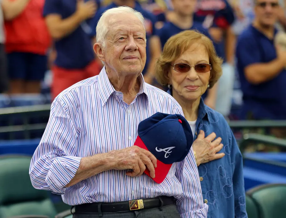 L'ancien président Jimmy Carter et son épouse, Rosalynn, se lèvent pour l'hymne national avant un match de baseball entre les Braves d'Atlanta et les Padres de San Diego, le 10 juin 2015.