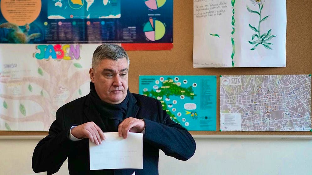 Croatia's President Zoran Milanovic prepares his ballot paper at a polling station during the presidential elections. Photo: Darko Bandic/AP/dpa