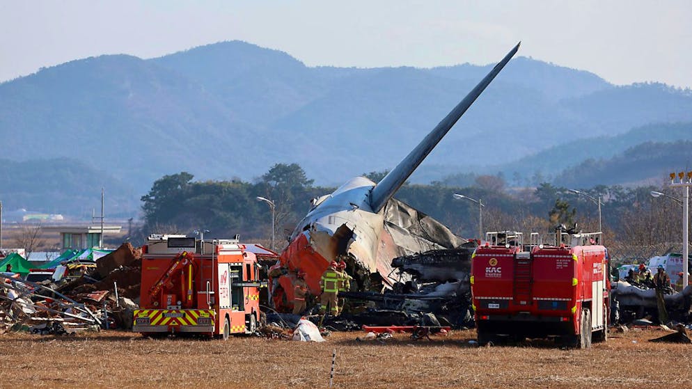 dpatopbilder - Feuerwehrleute und Rettungskräfte arbeiten am internationalen Flughafen von Muan. Bei der Landung am internationalen Flughafen von Muan in Südkorea ist ein Passagierflugzeug verunglückt. Foto: Cho Nam-soo/Yonhap/AP/dpa