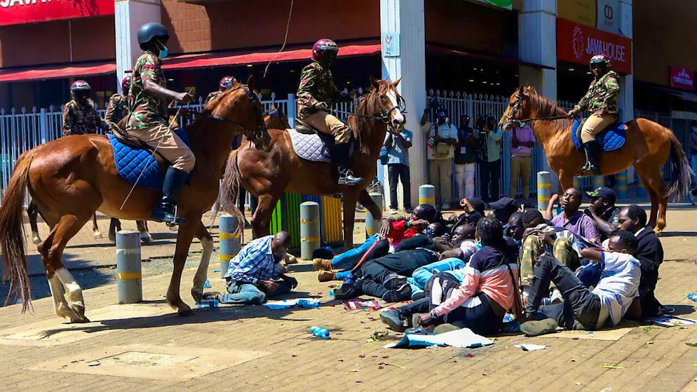 Police on horseback surround demonstrators during protests against kidnappings. Photo: Andrew Kasuku/AP/dpa