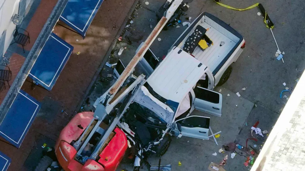 Eine schwarze Flagge mit weißer Schrift liegt zusammengerollt auf dem Boden hinter einem Pick-up-Truck, den ein Mann in eine Menschenmenge auf der Bourbon Street in New Orleans fuhr und dabei mehrere Menschen tötete und verletzte. Foto: Gerald Herbert/AP/dpa