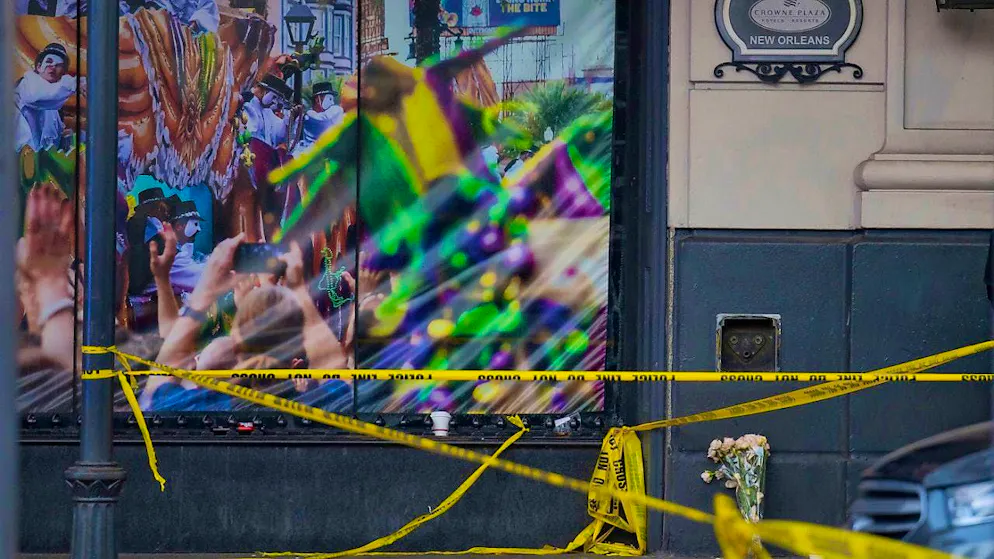 A man lays a bouquet of flowers at the intersection of Bourbon Street and Canal Street as investigations continue after a pickup truck was driven into a crowd of revelers early New Year's Day. Photo: Matthew Hinton/AP/dpa