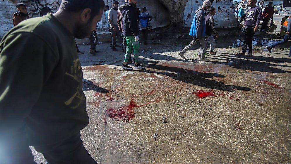 Le sol est maculé de sang après une frappe aérienne israélienne sur la route de Salah Al Din près du camp de réfugiés d'Al Maghazi, dans le centre de la bande de Gaza, le 2 janvier 2025. Selon le ministère de la Santé de Gaza, au moins dix Palestiniens sont morts à la suite de la frappe.