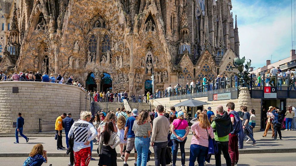 Turisti in coda per visitare la Sagrada Familia, iconica cattedrale di Barcellona.