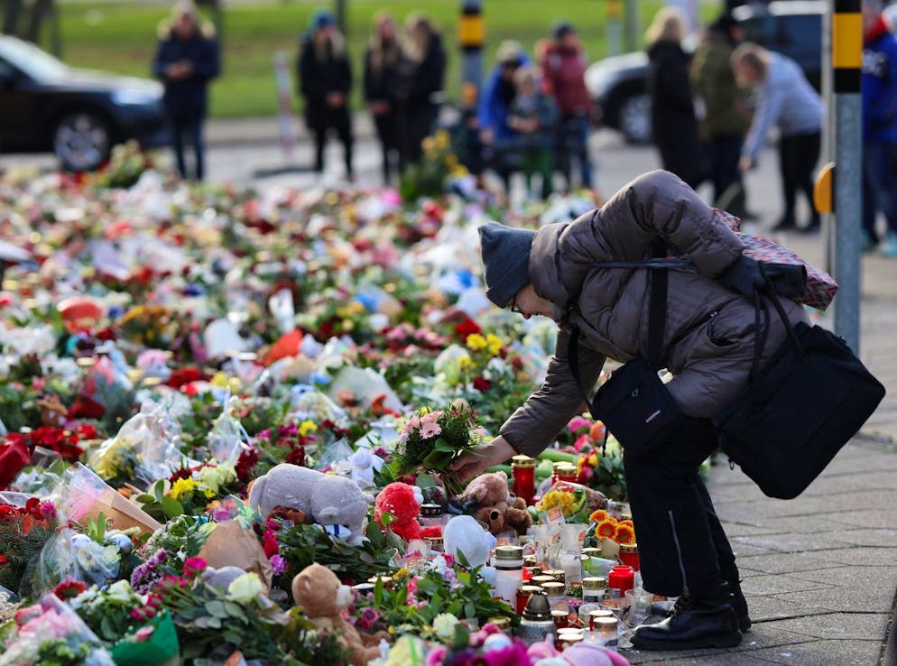 Saxe-Anhalt, Magdebourg : des personnes en deuil se tiennent devant l'église Saint-Jean, lieu central de commémoration après l'attentat sur le marché de Noël de Magdebourg, et y déposent des fleurs.
