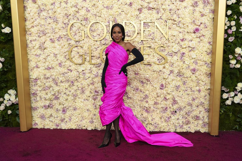 Kerry Washington arbore une robe drapée rose flashy à laquelle elle associe des gants longs.
