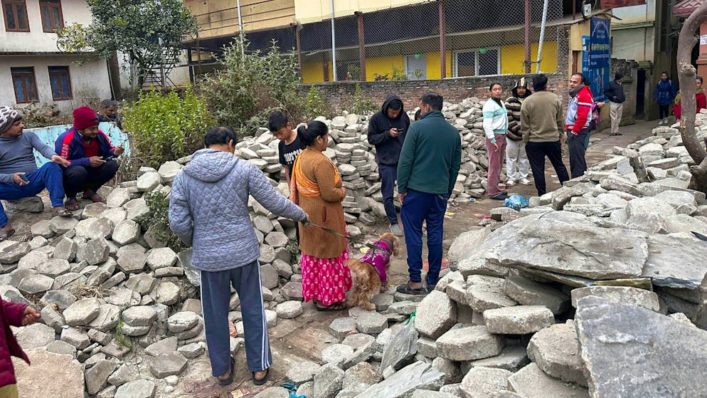 People gather outside their homes in Kathmandu on Tuesday: the severe earthquake in Tibet was also felt in the Nepalese capital.
