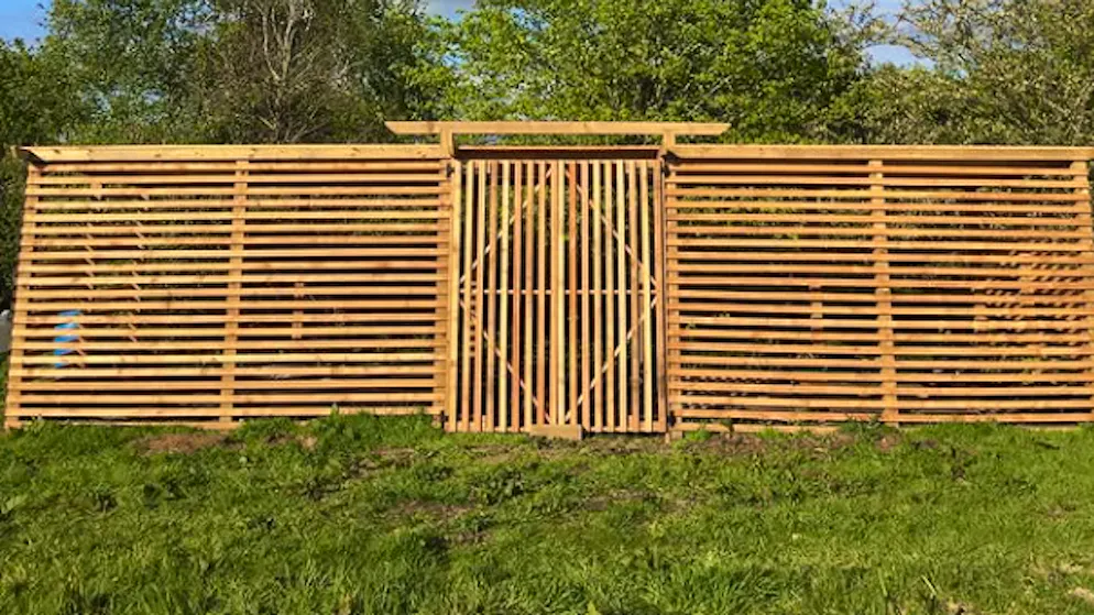 Eine Konstruktion aus Lärchenholz umgibt das Tiny House.