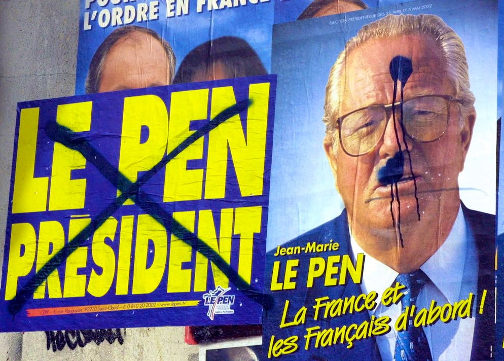 Une affiche électorale maculée du leader d'extrême droite Jean-Marie Le Pen, sur laquelle on peut lire « La France et les Français d'abord », est accrochée à un mur de Paris le lundi 22 avril 2002. Des manifestations spontanées ont éclaté dans toute la France après que M. Le Pen se soit qualifié dimanche pour le second tour de l'élection présidentielle, le 5 mai, face au président sortant, M. Chirac . (AP Photo/Michel Euler) (archive)