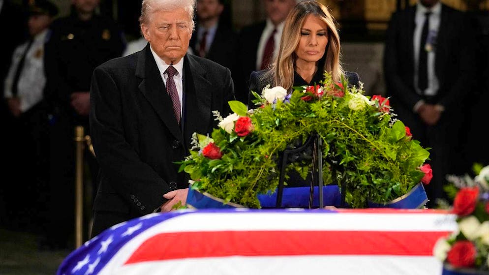 US President-elect Donald Trump and his wife Melania Trump stand in front of the flag-draped coffin of the late former President Jimmy Carter, laid out in the rotunda of the US Capitol in Washington. Photo: J. Scott Applewhite/AP/dpa
