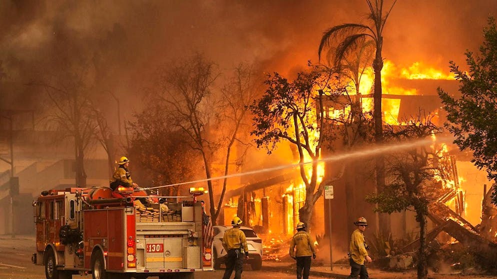 Wildfires in California: Thousands evacuated - Gallery. Firefighters extinguish a burning building on Lake Avenue in downtown Altadena. Photo: Chris Pizzello/AP/dpa