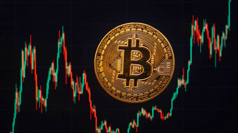 ILLUSTRATION - Eine Bitcoin-Münze liegt auf einem Bildschirm, der den Bitcoin - US-Dollar Kurs zeigt. Foto: Fernando Gutierrez-Juarez/dpa