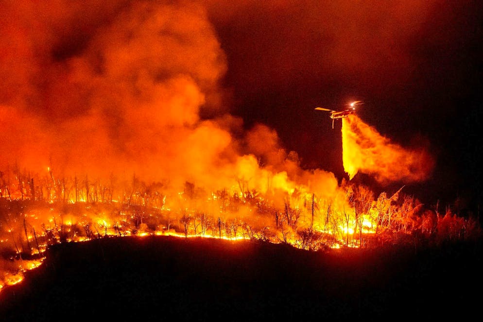 Wildfires in California: Thousands evacuated - Gallery. A helicopter drops water on the Thompson fire