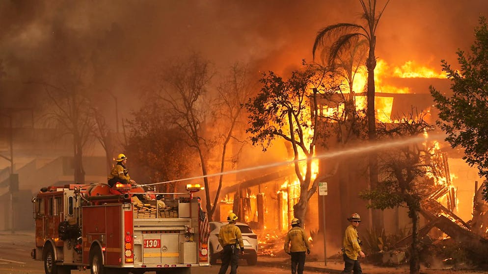 Waldbrände in Kalifornien: Tausende evakuiert - Gallery. Feuerwehrleute löschen ein brennendes Gebäude in der Lake Avenue in der Innenstadt von Altadena. Foto: Chris Pizzello/AP/dpa