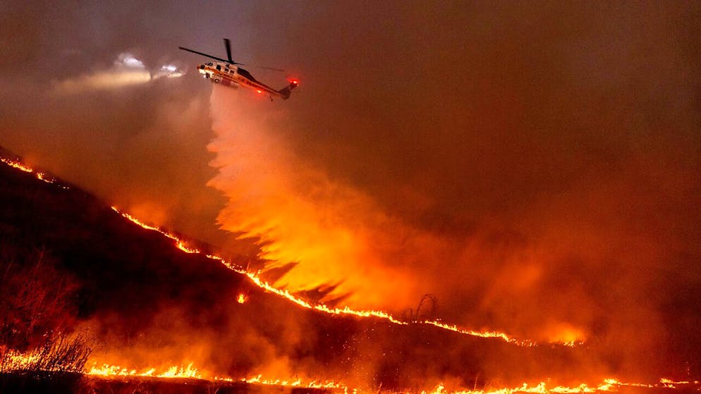 Ein Hubschrauber wirft Wasser auf das Kenneth-Feuer in den West Hills von Los Angeles. 