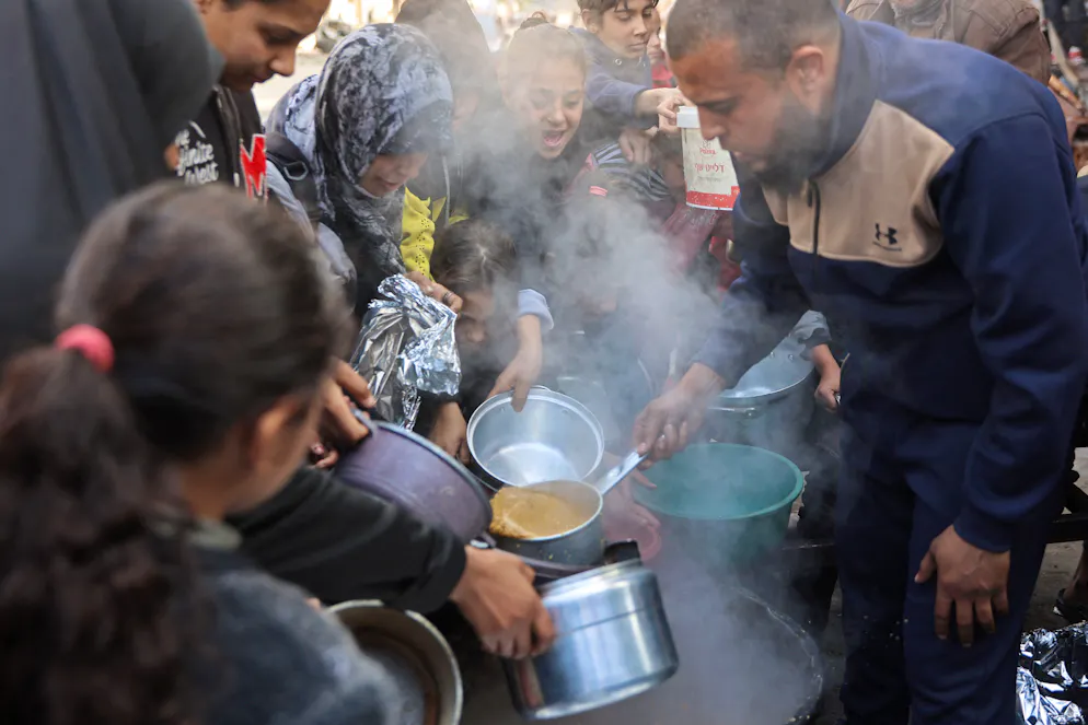 Des Palestiniens se rassemblent pour recevoir de l'aide alimentaire distribuée par des hospices caritatifs dans la ville de Gaza, le 11 janvier 2025. 