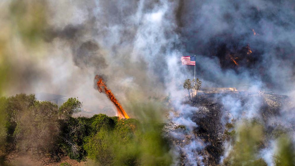 dpatopbilder - Eine amerikanische Flagge weht über einem Teil des Mandeville Canyon, der durch das Palisades-Feuer zerstört wurde. Foto: Mark Edward Harris/ZUMA Press Wire/dpa