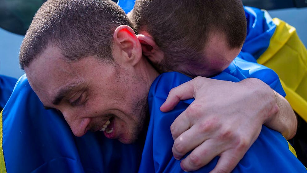 ARCHIV - Ein ukrainischer Soldat umarmt  nach seiner Rückkehr aus der Gefangenschaft seinen Kameraden bei einem Gefangenenaustausch in der Region Sumy. Foto: Evgeniy Maloletka/AP/dpa/Archivbild