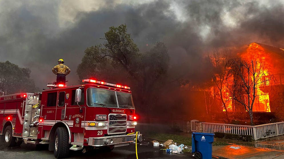 ARCHIV - Feuerwehrleute bekämpfen das Palisades-Feuer, das im Stadtteil Pacific Palisades in Los Angeles brennt. Foto: Eugene Garcia/AP/dpa/Archivbild