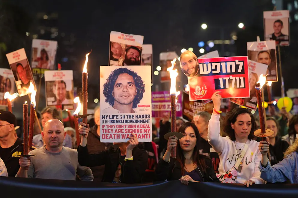 Des membres des familles des otages détenus par le Hamas à Gaza et leurs sympathisants brandissent des torches et des affiches alors qu'ils réagissent aux informations sur le cessez-le-feu lors d'une manifestation appelant à un cessez-le-feu et à la libération des otages, devant le siège du parti Likoud à Tel Aviv, en Israël, le 15 janvier 2025.