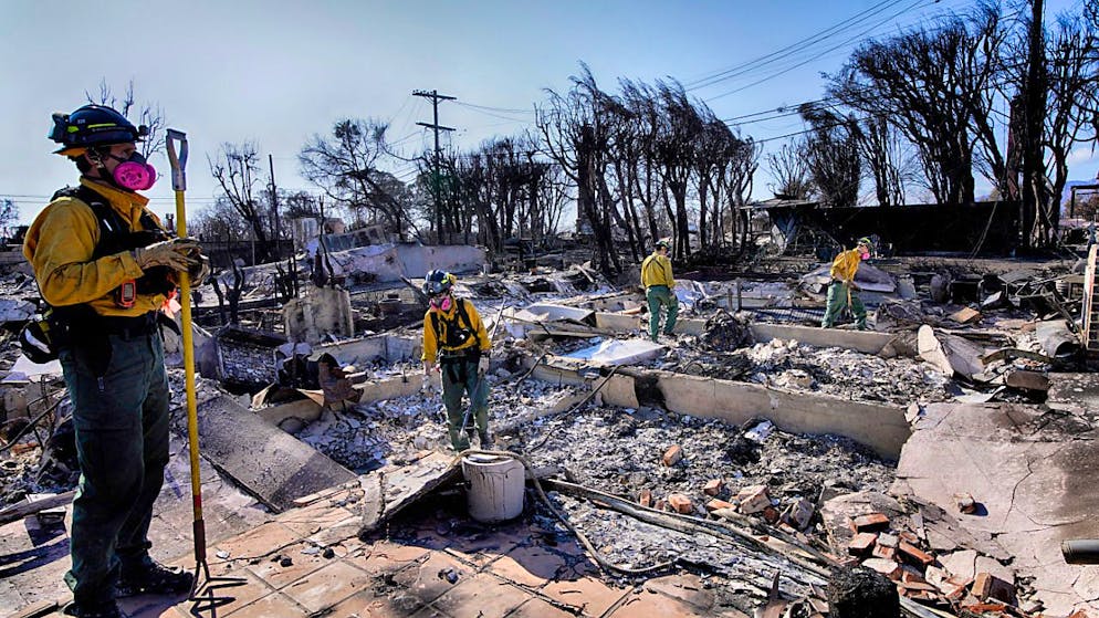 Feuerwehrmänner überprüfen Brandruinen im Pacific-Palisades-Viertel von Los Angeles. Foto: Richard Vogel/AP/dpa