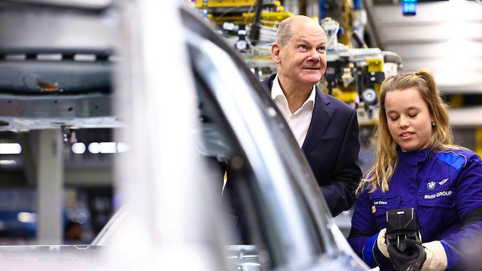 German Chancellor Olaf Scholz talks to a worker on the assembly line during a visit to the BMW plant in Munich. (archive picture)