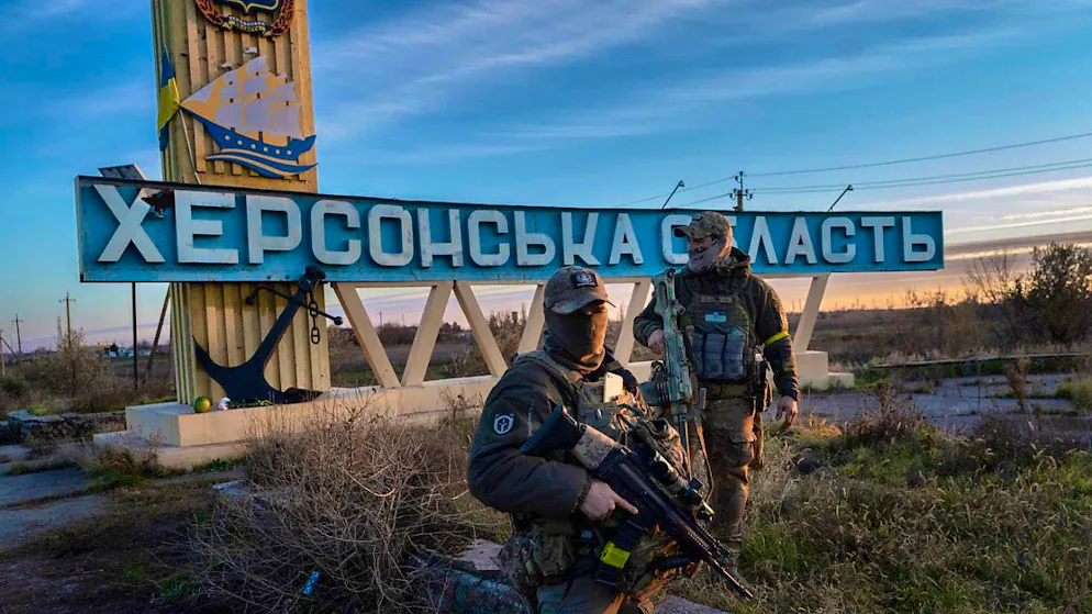 ARCHIVE - Two Ukrainian soldiers stand next to a sign reading "Kherson region". Photo: Bernat Armangue/AP/dpa