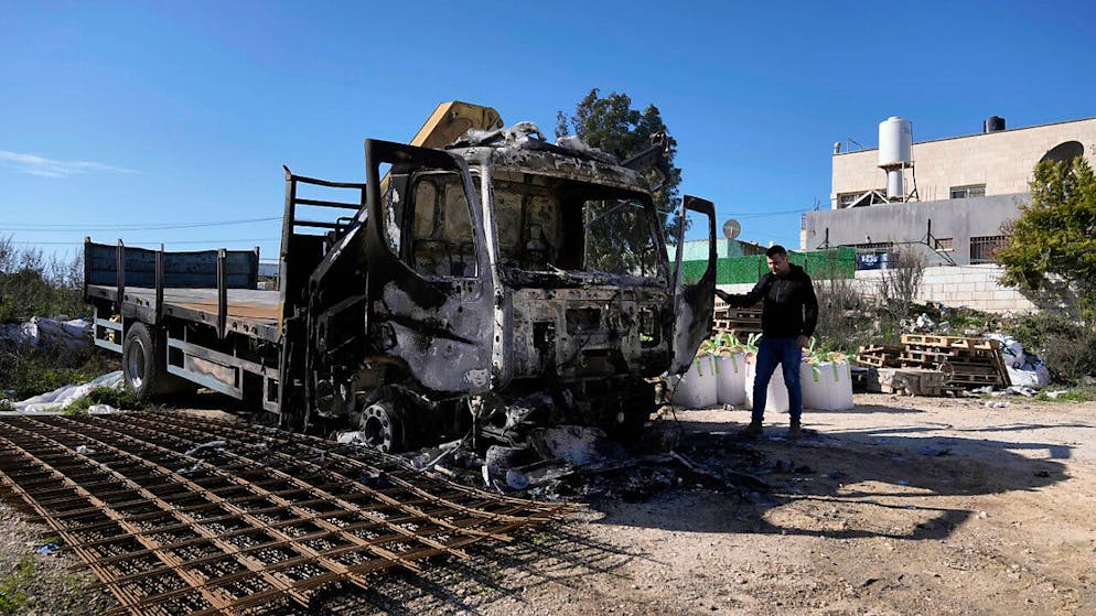 Ein Palästinenser steht neben einem Lastwagen, der bei einem Angriff israelischer Siedler im Westjordanlanddorf Jinsafut in Brand gesetzt wurde. Foto: Majdi Mohammed/AP/dpa