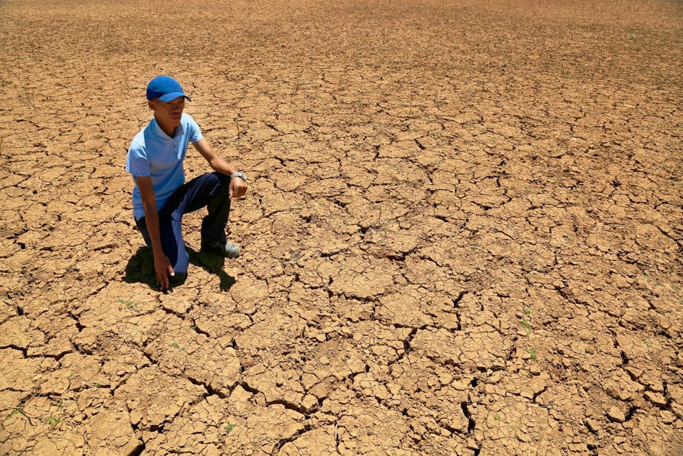 Un contadino si inginocchia in fondo a una pozza d'acqua prosciugata in Sudafrica. Secondo i promotori, la Svizzera, in quanto Paese ricco, deve assumersi le proprie responsabilità anche nei confronti dei Paesi del Sud.