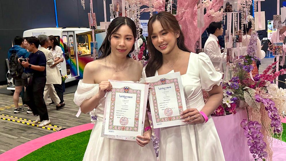 Ein frisch verheiratetes Paar feiert am ersten Tag der «Ehe für alle» in Thailand in der Paragon Hall. Seit dem Morgen fand dort eine Massenhochzeit statt. Die thailändische Regierung hatte dem Gesetz zu gleichgeschlechtlichen Ehen im vergangenen Jahr zugestimmt. Nun trat es in Kraft. Foto: Carola Frentzen/dpa