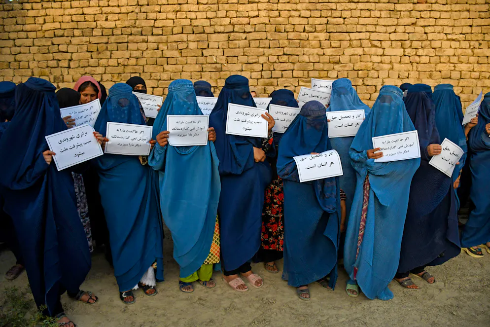 Des femmes afghanes vêtues d'une burqa brandissent des pancartes alors qu'elles manifestent pour leur droit à l'éducation, à Mazar-i-Sharif, le 12 août 2023. Reclus dans son fief du sud de l'Afghanistan, le chef suprême des talibans, Hibatullah Akhundzada, est la pierre angulaire du mouvement qui dirige le pays sans partage depuis qu'il a repris le pouvoir en 2021, en appliquant strictement la loi islamique.