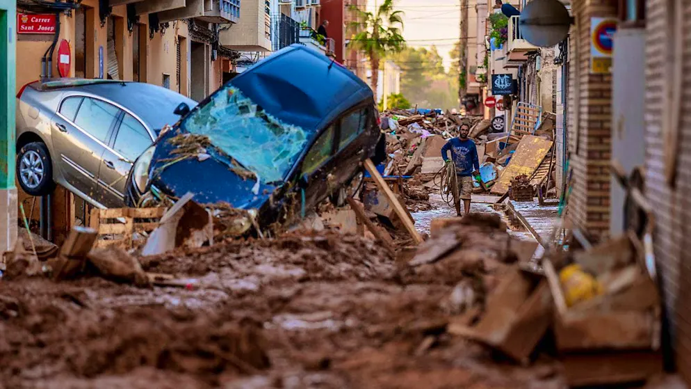 Cars pile up in a street affected by the floods in Valencia.